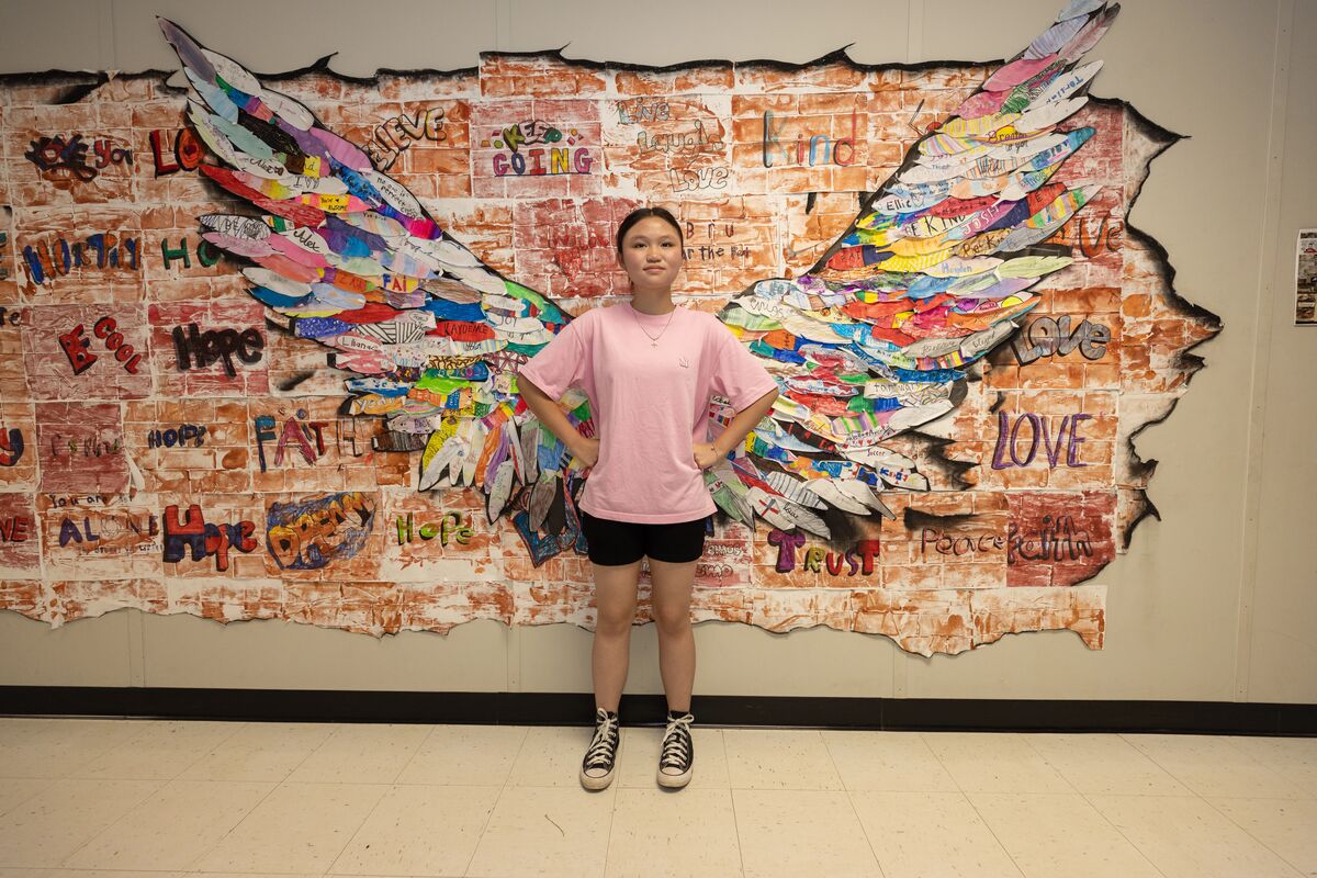 student posing at art display